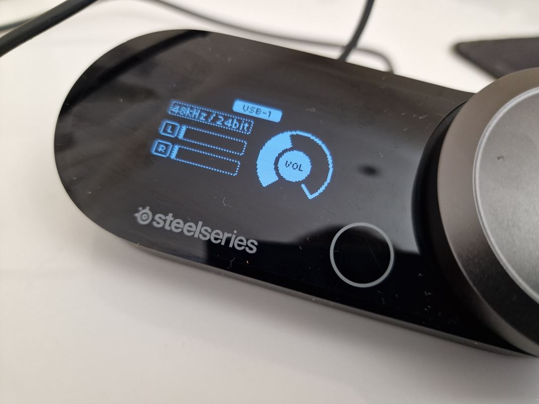 SteelSeries Arctis Nova Pro Receiver m displej, ktor ukazuje hlasitos a kvalitu, plus ostatn nastavenia.